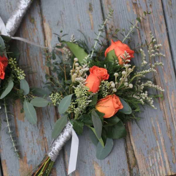 Orange rose bouquet with eucalyptus and white filler flowers
