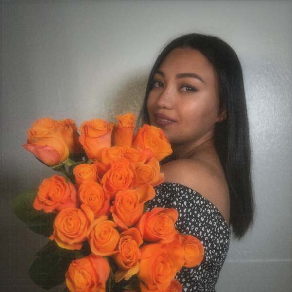 Woman holding a large bouquet of orange roses