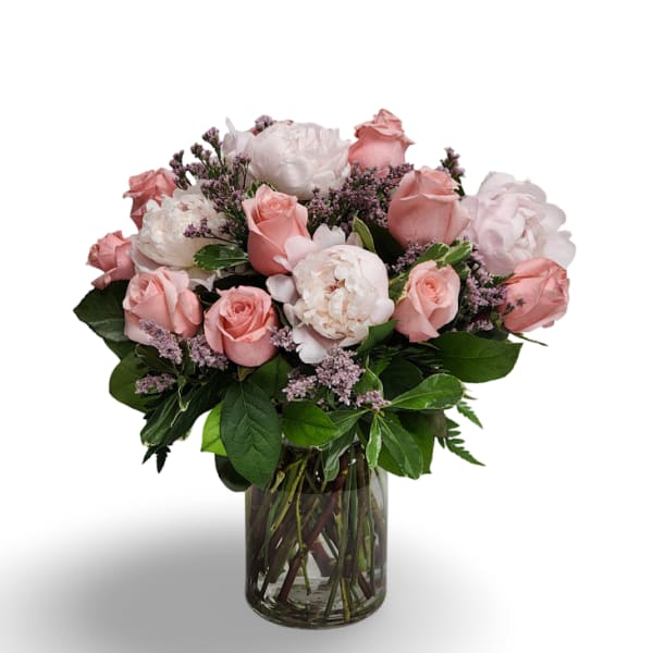 Pink roses and white peonies in a clear glass vase