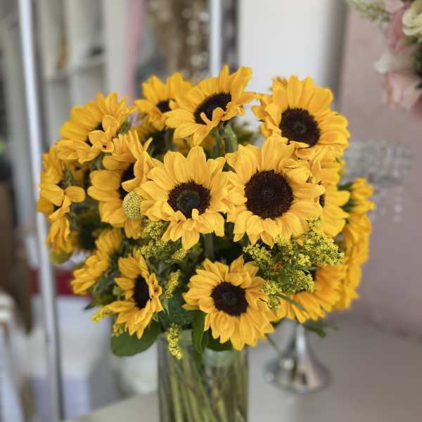 Bouquet of yellow sunflowers in a clear glass vase