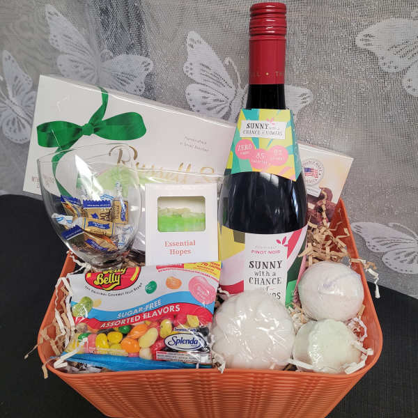 Gift basket with wine, candy, a glass, and bath items
