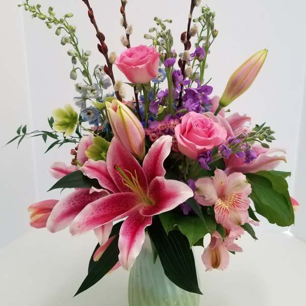 Pink lilies and roses in a green vase