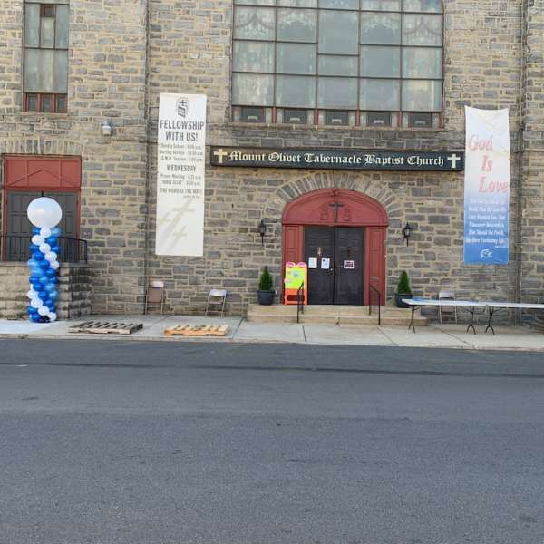 Church entrance with blue and white balloon columns and banners