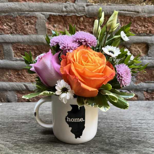 Bouquet of orange and lavender flowers in a white mug