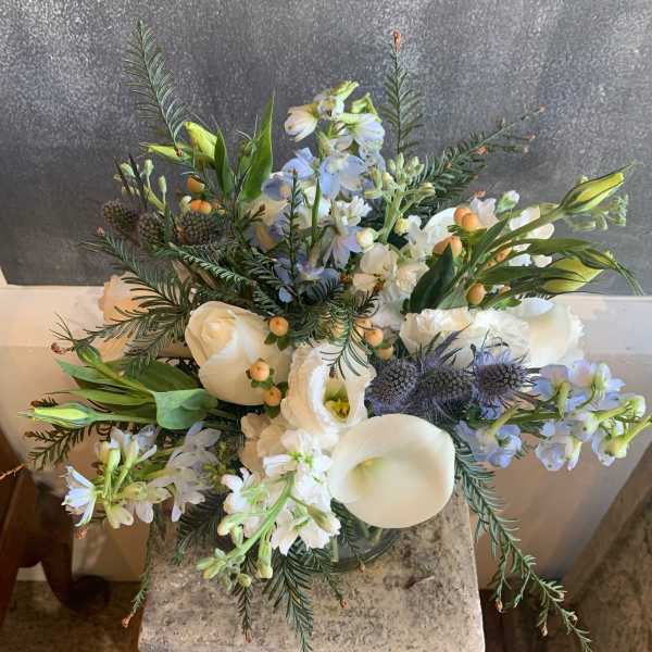 White and pale blue floral arrangement with calla lilies and roses