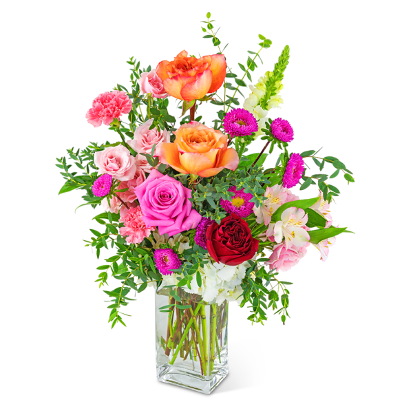 Mixed bouquet of roses, carnations, and alstroemeria in a clear glass vase