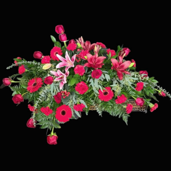 Pink floral casket spray with lilies, roses, and gerbera daisies