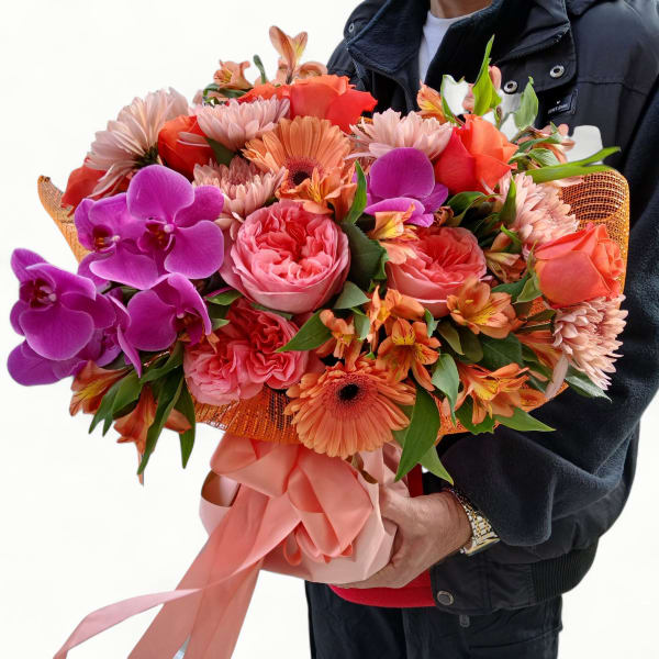 Large hand-tied bouquet of orange and pink flowers with bright purple orchids and peach ribbon wrap