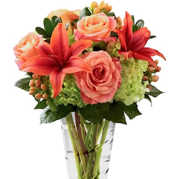 Pink roses and red lilies in a clear glass vase