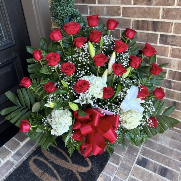 Large red rose and white lily arrangement with a red bow