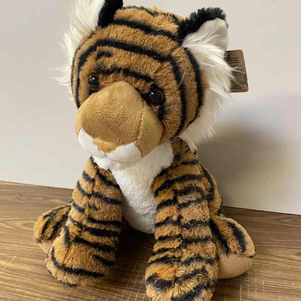 Plush tiger stuffed animal sitting on a wooden surface
