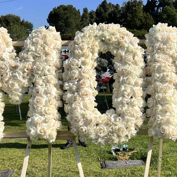 Large white rose floral display spelling a word on easels outdoors