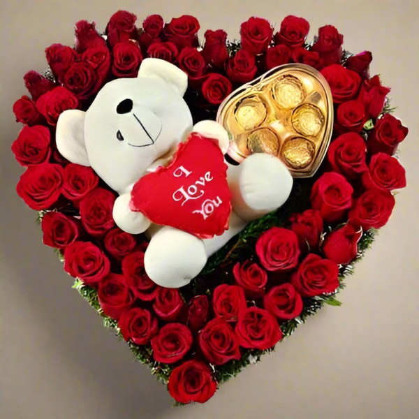 Heart-shaped rose arrangement with a teddy bear and chocolates