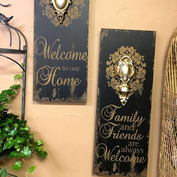 Two decorative wall plaques with gold accents and welcome text