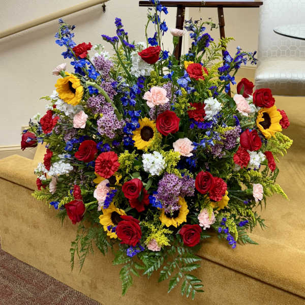 Large mixed flower arrangement with red roses and sunflowers