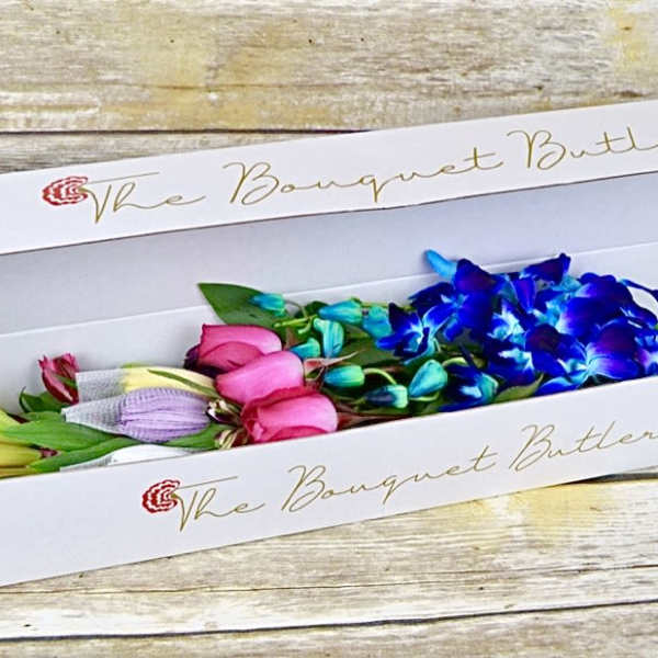 Box of colorful flower stems with blue orchids and pink blooms