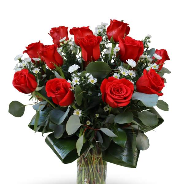 Red roses and white daisies in a clear glass vase