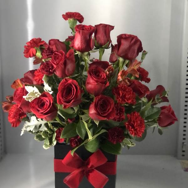 Red roses and carnations in a black box with a red ribbon