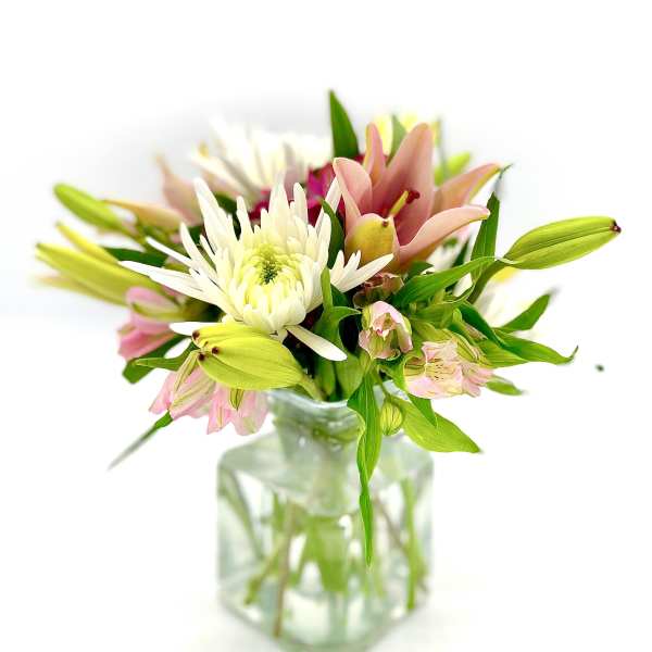 Bouquet of lilies, white chrysanthemum, and pink alstroemeria in a glass vase