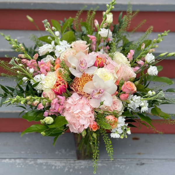 Mixed bouquet of pink, white, and peach flowers with orchids and roses