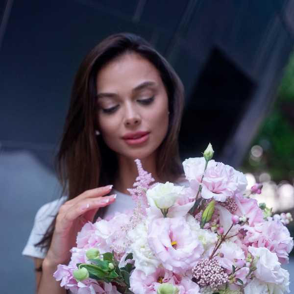 Woman holding a pink and white bouquet of mixed flowers