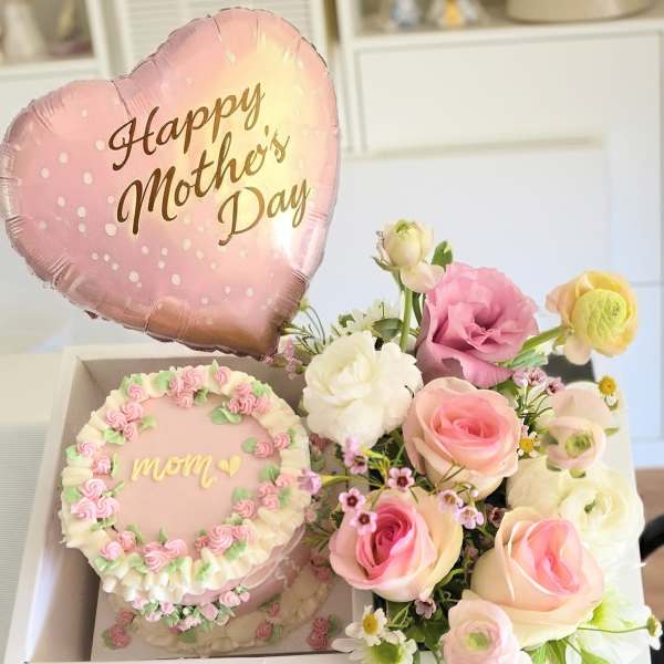 Mother's Day gift box with pink balloon, cake, and pastel flower bouquet