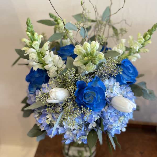 Blue and white floral arrangement in a glass vase