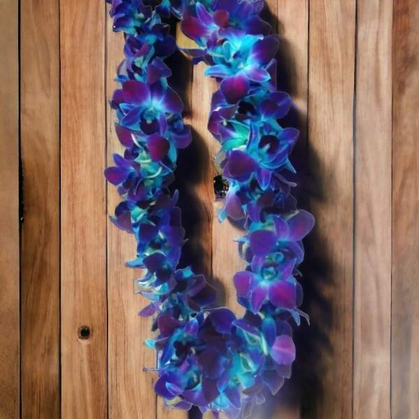 Purple and blue flower lei hanging against a wooden wall