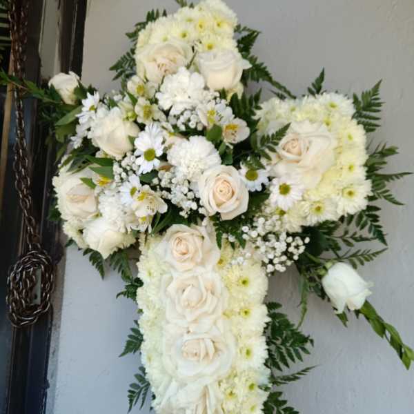 White floral cross arrangement with roses and daisies