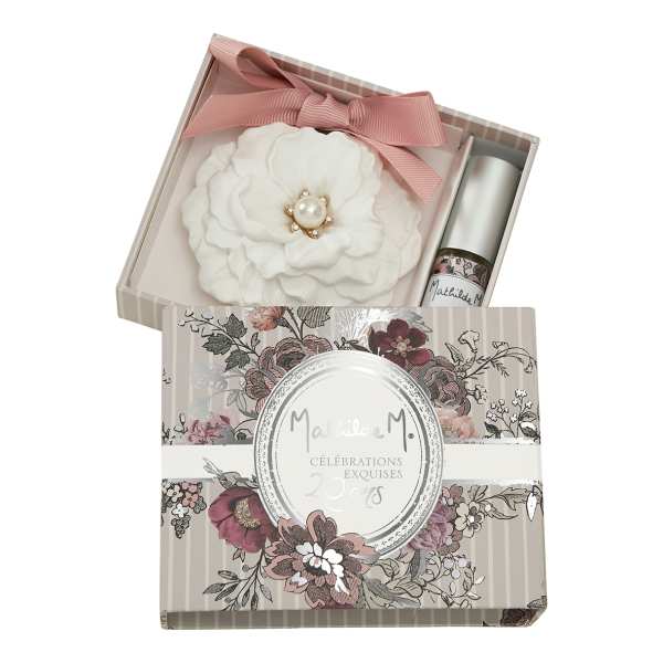 White fabric flower in a gift box with a pink ribbon and small bottle