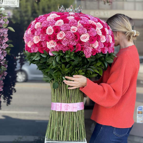 Large bouquet of pink and red roses with a crown topper