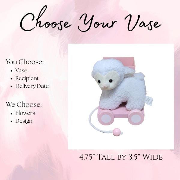 Plush lamb on a pink wheeled cart with a small box behind it