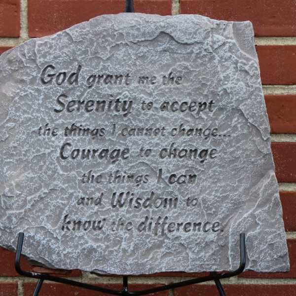 Engraved gray stone plaque with a quote on a brick wall