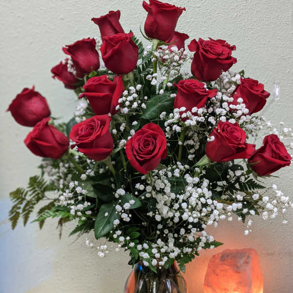 Red roses with white baby's breath in a glass vase