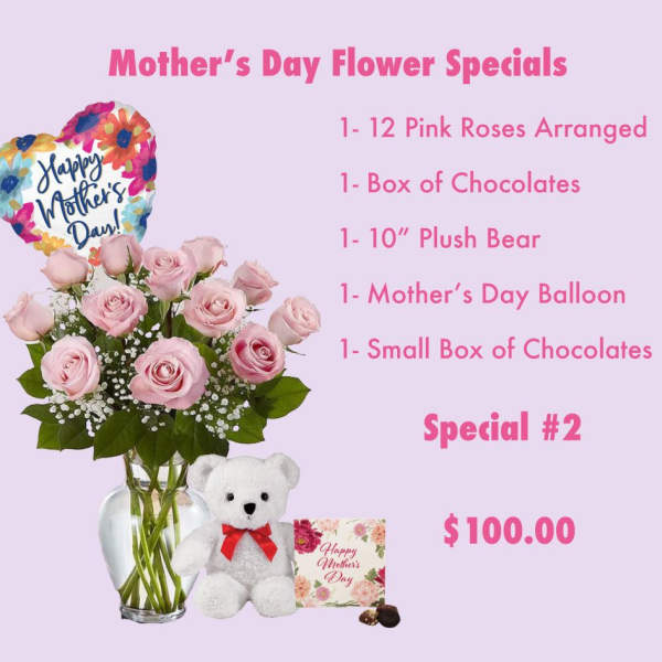 Pink roses in a glass vase with a heart balloon, teddy bear, and chocolates