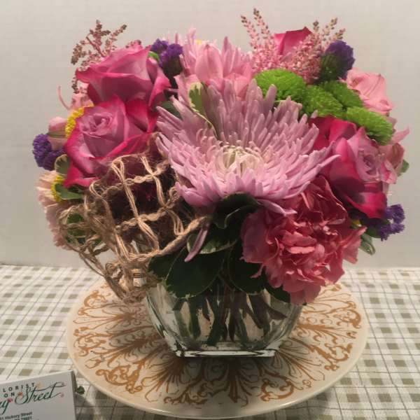 Pink and purple mixed flower arrangement in a clear glass vase