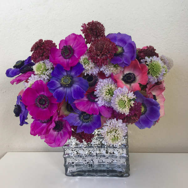 Bouquet of purple, pink, and white flowers in a clear glass vase