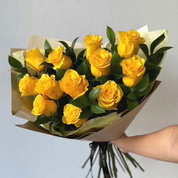 Bouquet of yellow roses wrapped in brown paper