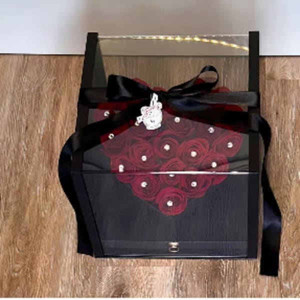 Black gift box with red rose design and a black ribbon bow