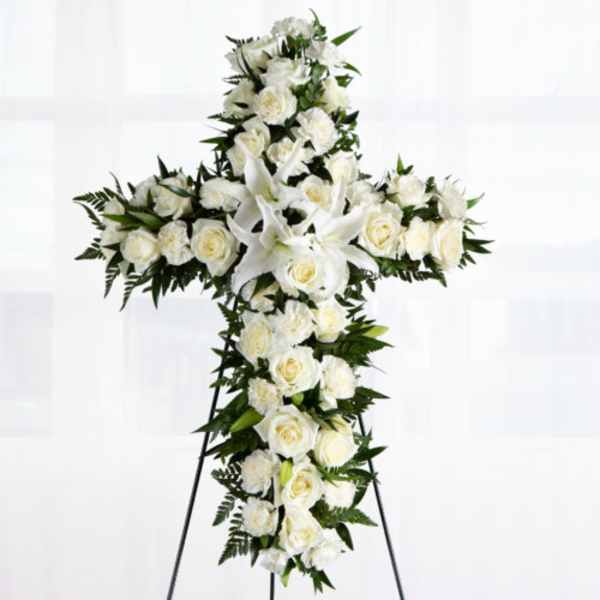 White floral cross wreath on a standing easel
