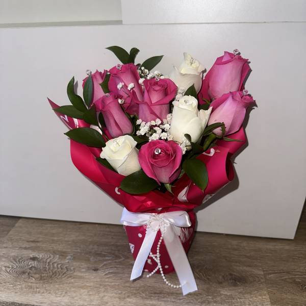 beautiful fuchsia and white roses, glass vase with pearl ribbon