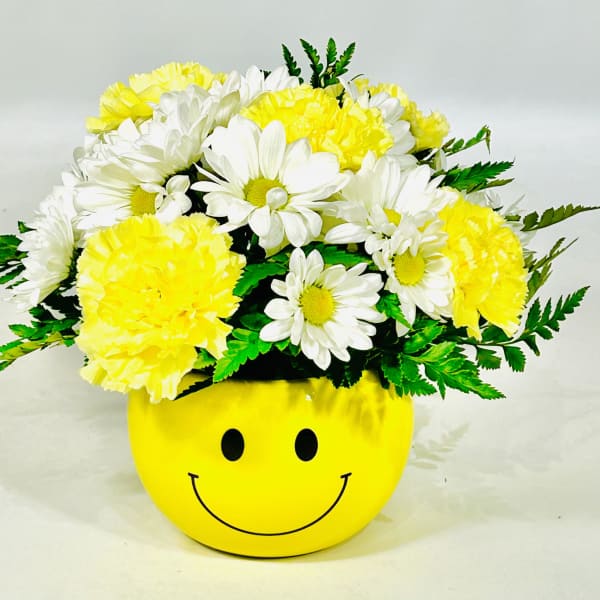 Yellow and white daisy bouquet in a smiley-face pot
