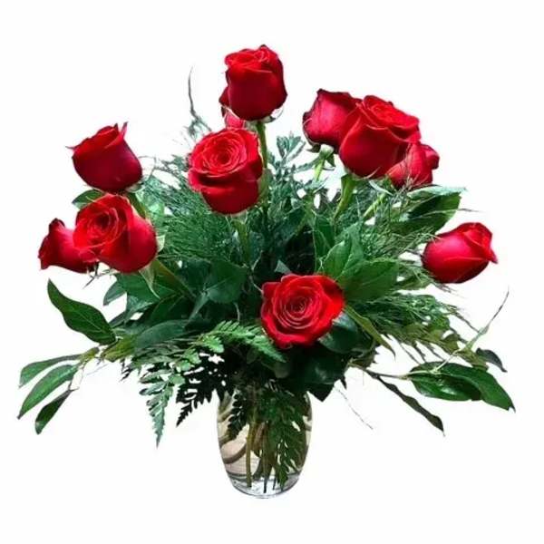 Red roses arranged in a clear glass vase with greenery