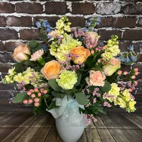 Mixed pastel flower arrangement in a white vase