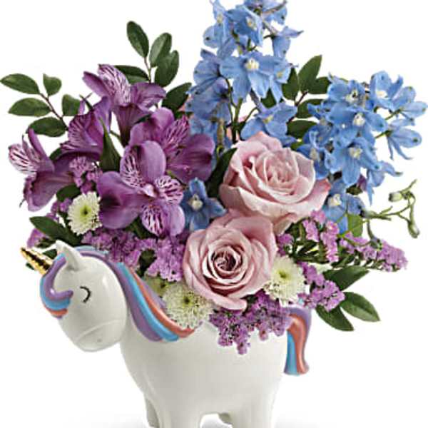 Bouquet of pink and blue flowers in a unicorn-shaped vase