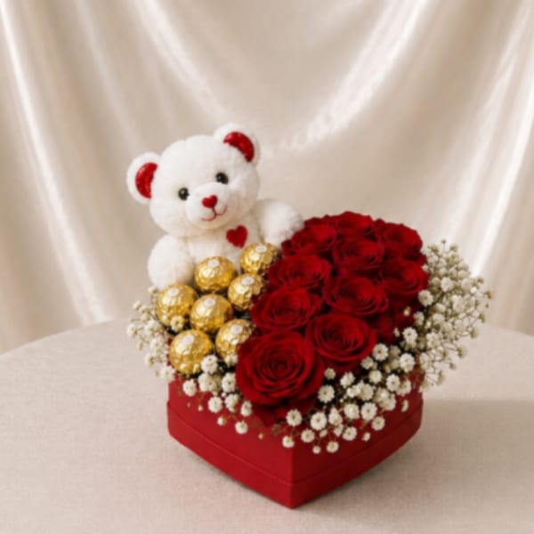 Red roses and a teddy bear in a heart-shaped gift box