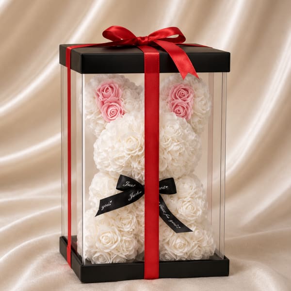 White rose teddy bear in a clear gift box with a red ribbon