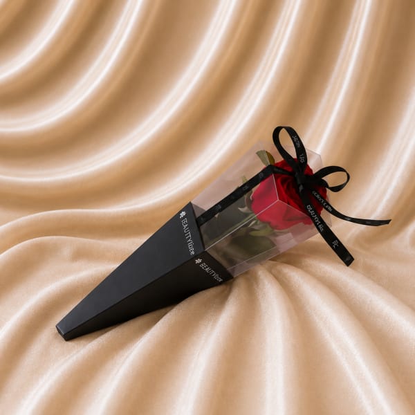 Single red rose in a clear box with a black ribbon