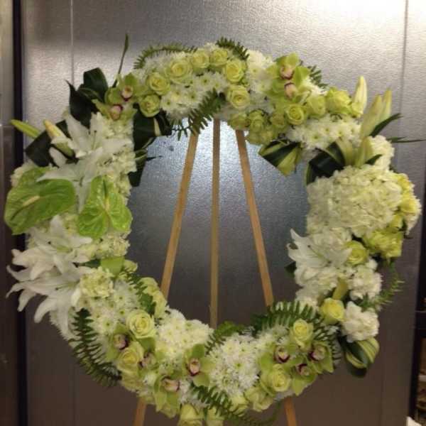 Large floral wreath of white and pale green flowers on an easel