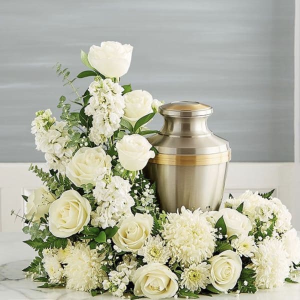 White roses and chrysanthemums arranged around a metal urn